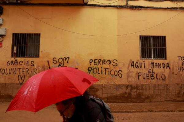 A man walks past graffiti reading 