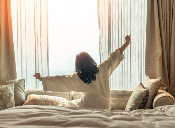 A woman stretches after waking from a long sleep