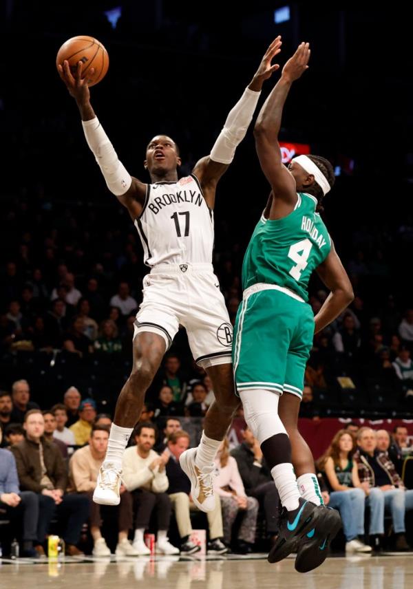 Brooklyn Nets guard Dennis Schroder (L) looks to put up a shot past a defending Boston Celtics guard Jrue Holiday (R) in the first half at the Barclays Center in Brooklyn, New York, USA, Thursday, November 13, 2024