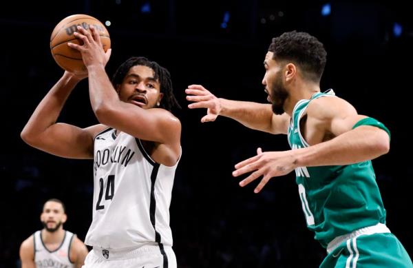 Brooklyn Nets guard Cam Thomas looks to pass past a defending Boston Celtics forward Jayson Tatum in the first half at the Barclays Center