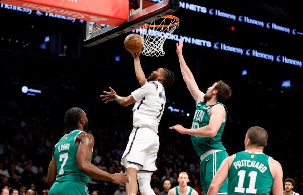 Brooklyn Nets guard Cam Thomas (L) puts up a shot past a defending Boston Celtics guard Jaylen Brown (L) Boston Celtics center Luke Kornet (R) in the first half at the Barclays Center in Brooklyn