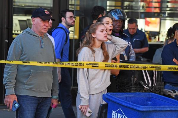 People look on at the scene of the shooting.