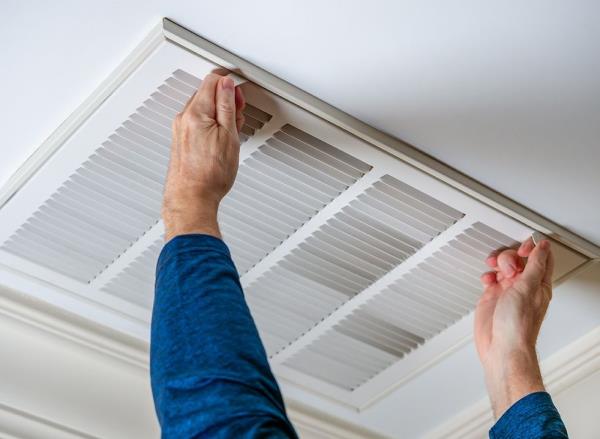 A man opens the ventilation system in a home