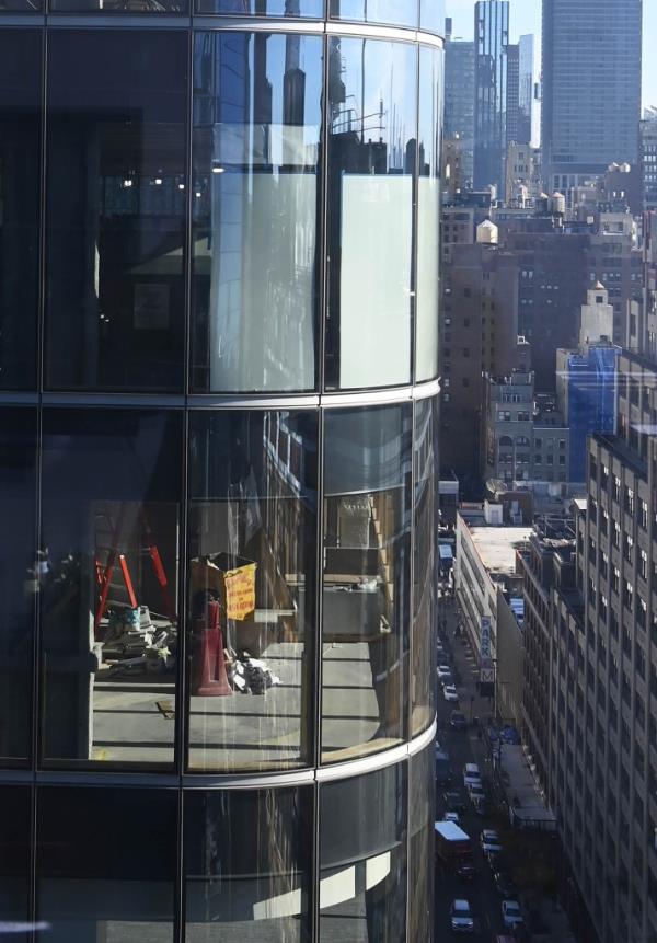 Co<em></em>nstruction workers at a Manhattan building site across from FIT student dorms, with white sheets hung in windows following peeping complaints.