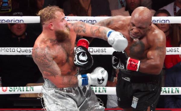 Mike Tyson (black gloves) fights Jake Paul (silver gloves) at AT&T Stadium.