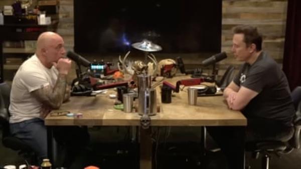 rogan and musk sit across the table from each other