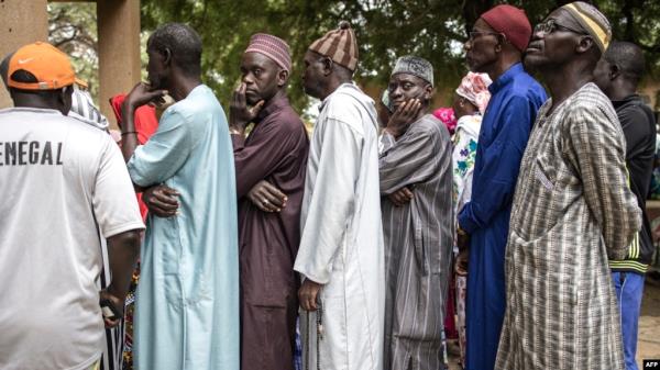 Voters wait in line outside a voting station in the fishing village of Ndayane on Nov. 17, 2024, during Senegal's parliamentary elections, with the country's new leaders aiming for a clear majority to see through their ambitious reform agenda.