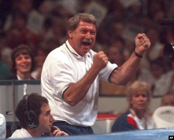 FILE - Bela Karolyi reacts with joy as his gymnastics student Kerri Strug finishes a routine on the balance beam during the optio<em></em>nal portion of the US Olympic Trials in gymnastics, June 30, 1996, in Boston.