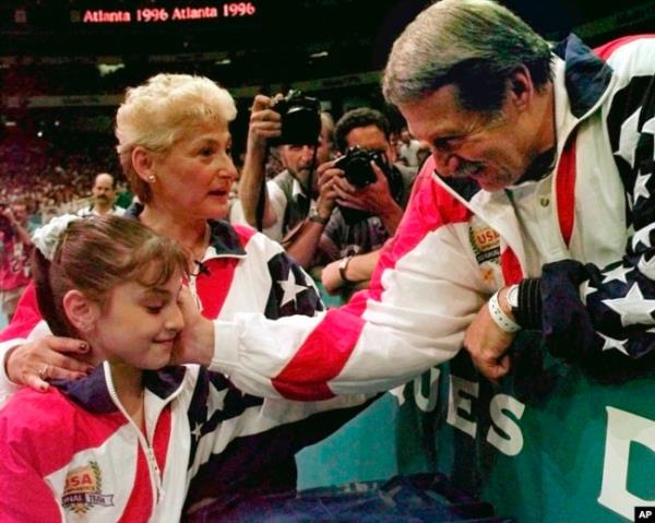 FILE - Bela Karolyi co<em></em>ngratulates Dominique Moceanu after the United States captured the gold medal in the women's team gymnastics competition at the Centennial Summer Olympic Games in Atlanta, July 23, 1996.