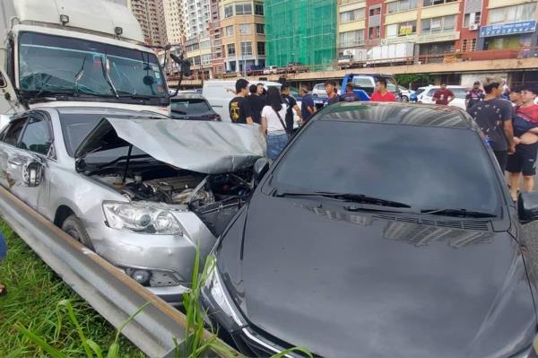 Three individuals, including a woman, suffered minor injuries after a five-to<em></em>nne lorry rammed 11 cars and a motorcycle along the Middle Ring Road 2 yesterday. — Picture courtesy of the Fire and Rescue Department 