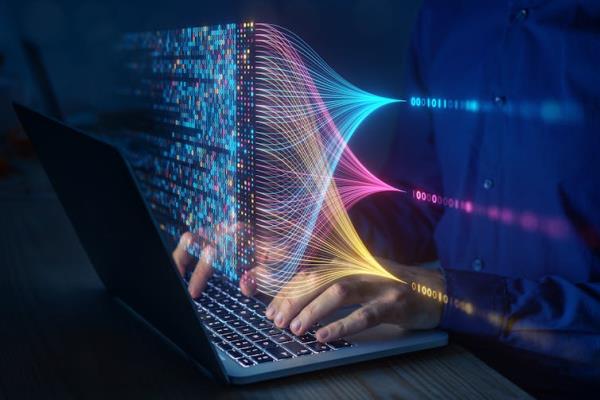 Close up of a pair of lines typing on a keyboard while colourful lines of code are seen floating above the keyboard